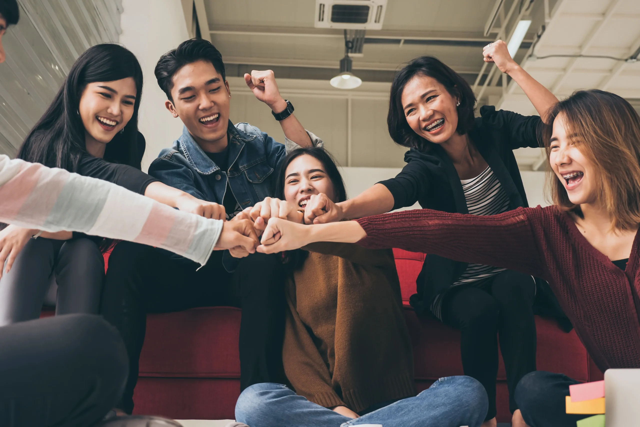 A group of friends doing a fist-bump